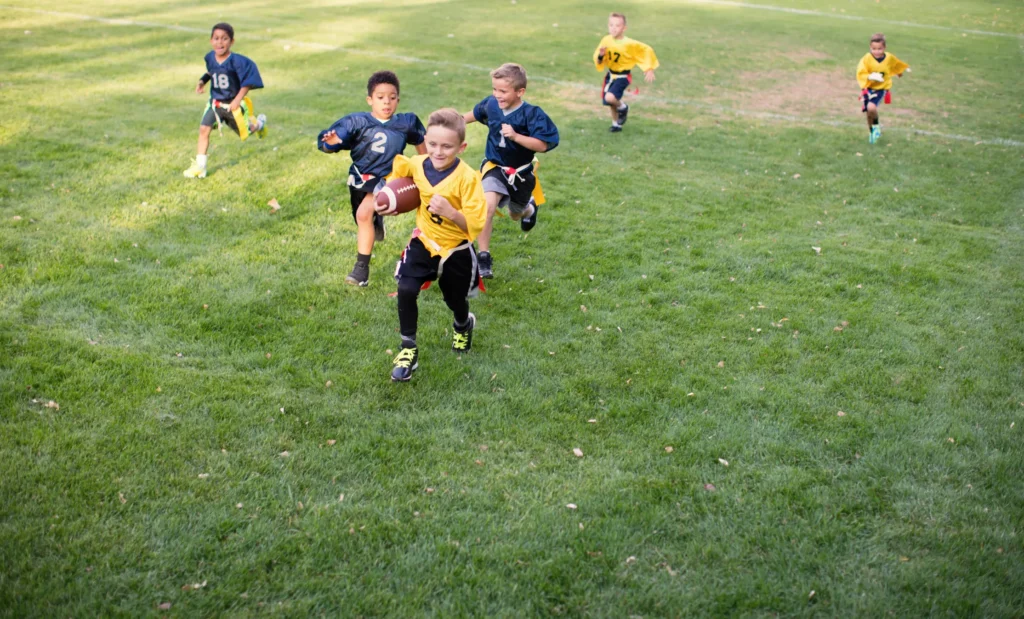Kids run during a game of flag football