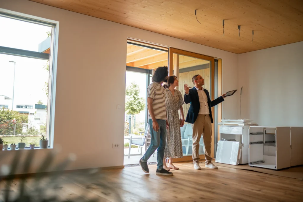 A real estate agent walks a young couple through a home as they think of questions to ask as a first time home buyer.