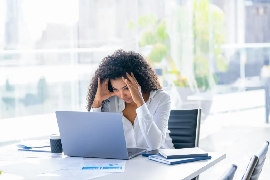 A woman holds her head in her hands in frustration after dealing with the wrong Triangle Realtor
