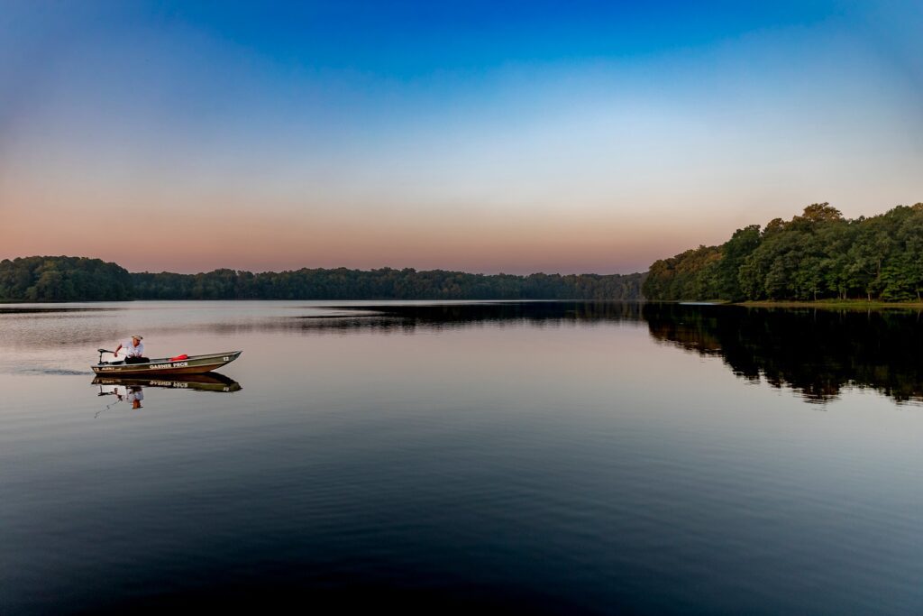 A man boats on a lake in Garner NC, which is one of the best suburbs for families and young professionals.