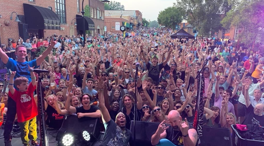 A crowd waves at the camera at an event in Wake Forest, which is one of the best suburbs for families and young professionals.