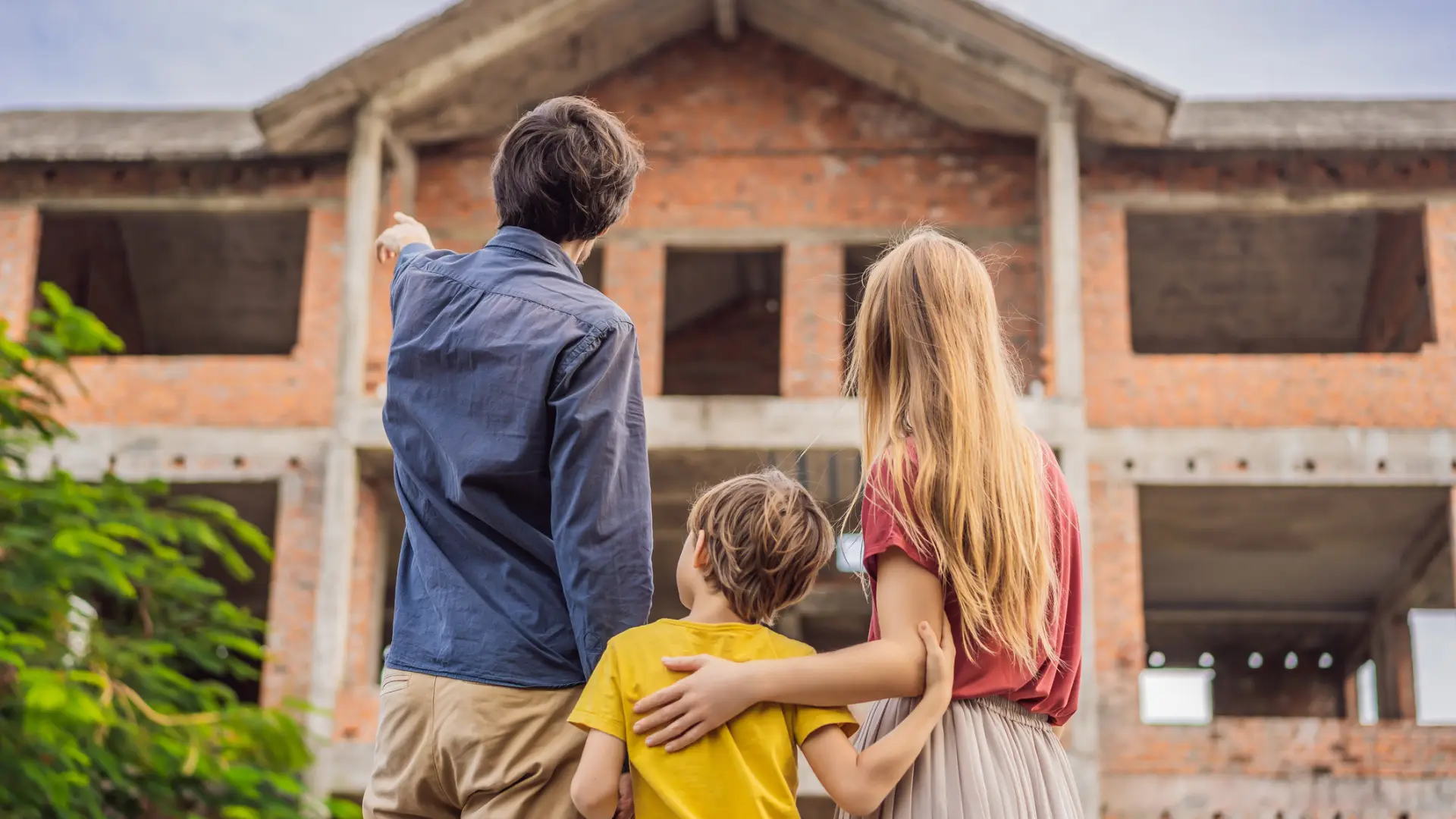 A husband points out features of a new construction home as the family weighs townhome vs single-family home new construction