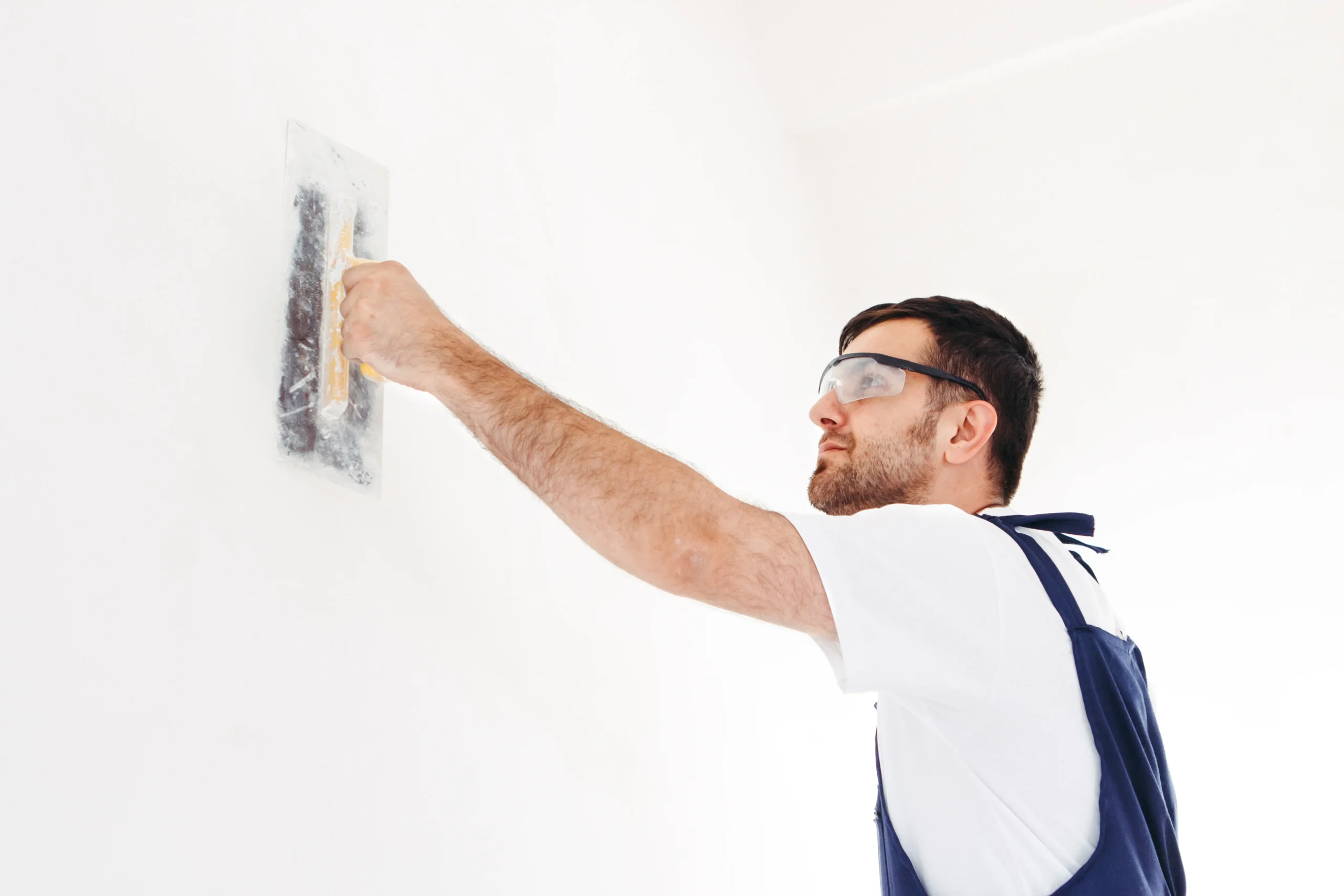 A contractor repairs drywall
