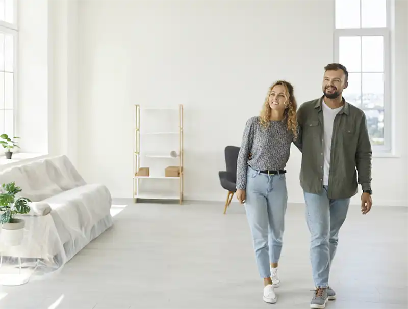 A couple walking through a house smiling