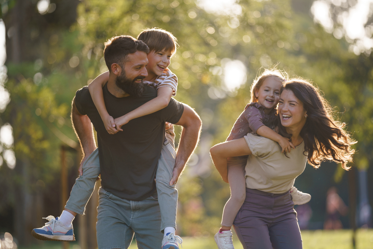 Happy family enjoying piggyback ride in park